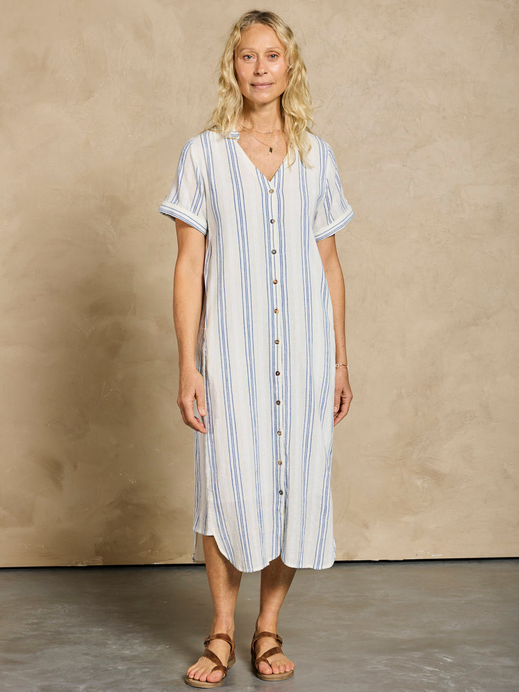 Woman wearing a striped dress against a beige background